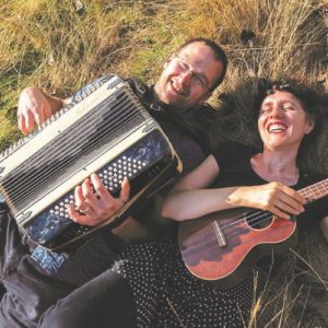 Régine Galle et Fabian Beghin dans l'herbe avec leur accordéon et leur ukulélé