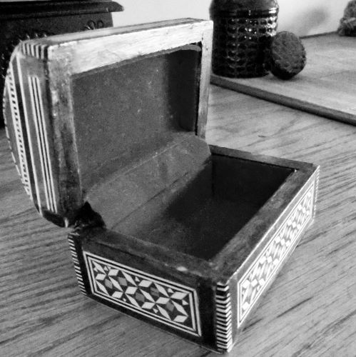 Photo en noir et blanc d'un coffret en bois ouvert, par Rino Noviello