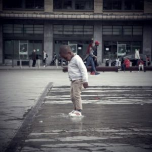 traversées : un enfant capture un jet d'eau place Flagey à Bruxelles