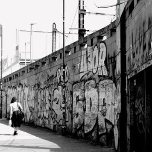 jeune femme qui marche le long d'un mur tagué