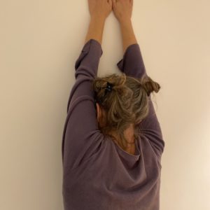 femme de dos face à un mur blanc